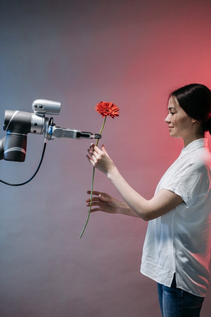 Eine Blume wird einer Frau von einem Roboterarm überreicht.